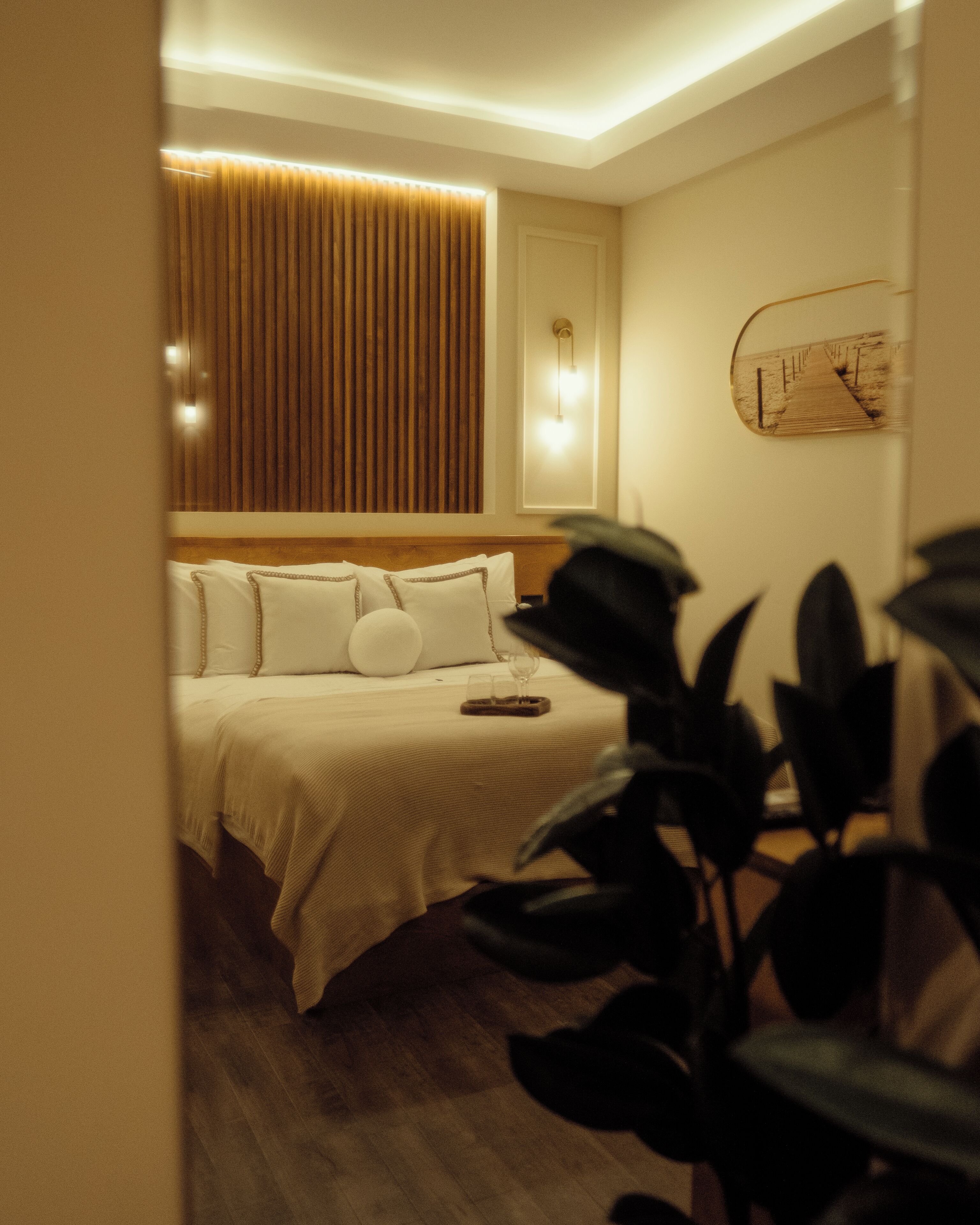 Una habitación de hotel con cama, mesita de noche y un reloj en la pared.