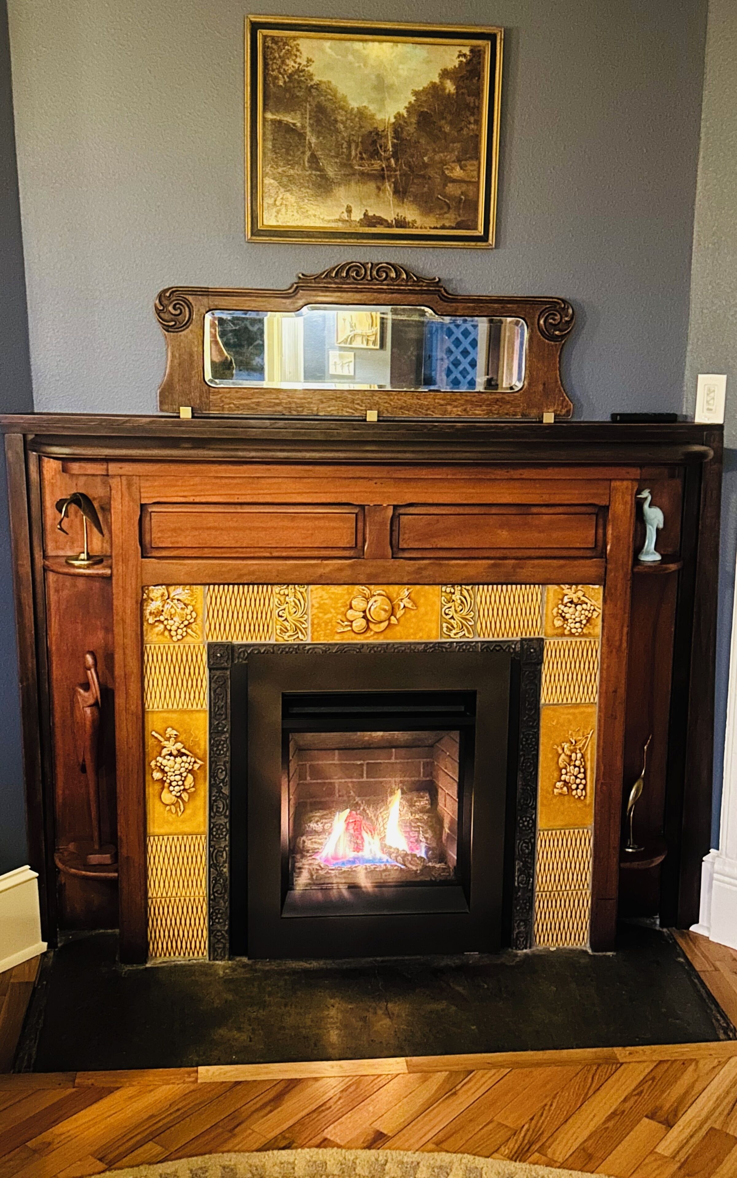 A fireplace with a decorative mantel and a framed painting above it.