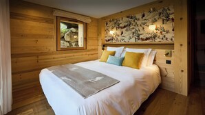 A wooden room with a bed, a window, and a wall with a mural. - Chalet Anselme - luxury stay for 10 with Mont Blanc views - OVO Network (Cordon)