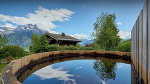 A wooden pool with a clear reflection of the sky and mountains. - Chalet Anselme - luxury stay for 10 with Mont Blanc views - OVO Network (Cordon)