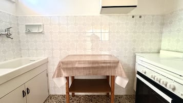 Een koelkast, een oven, eettafels