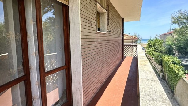 A building with large windows, a balcony, and a view of the sea. - RM01 – Senigallia, three-room apartment facing the sea with parking space (Senigallia)