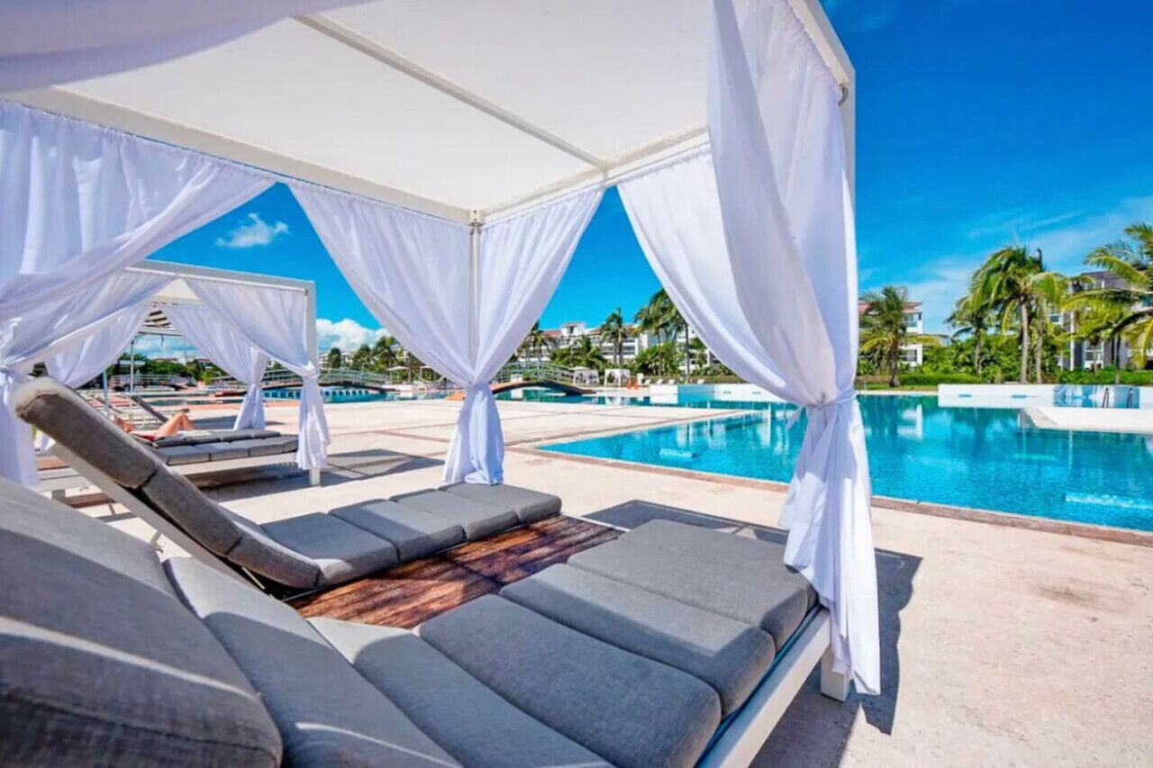 Un espace aménagé au bord de la piscine, avec des chaises longues et un auvent.