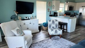 A modern kitchen with white cabinets, a built-in microwave, and a refrigerator. - Stunning balcony sunsets, 2 minute walk to beach, lil piece of heaven! (Navarre)