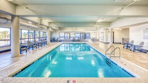 An indoor swimming pool with clear blue water, surrounded by lounge chairs and a tiled floor. - The Palms 804 - RELAX AT THE  BEACH IN THIS GORGEOUS GULF FRONT CONDO! (Orange Beach)