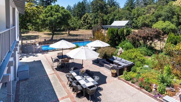 Una zona con patio, piscina, mobili da esterno e giardino.