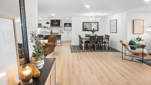 En moderne stue med spiseplads, trægulv og tidstypiske møbler.