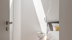 Ein Schlafzimmer mit Bett, Nachttisch und einer Tür.