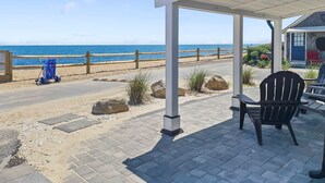 A covered outdoor seating area with a view of the beach and ocean. - Beachfront Escape in Dennis Port (Dennis Port)