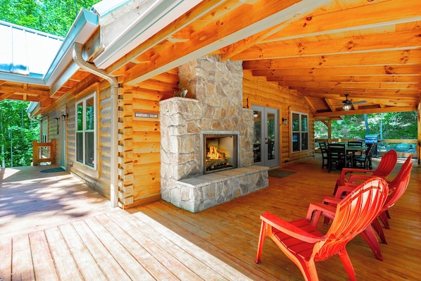 A log cabin with a stone fireplace, wooden deck, and outdoor seating area. - Newly Built, Secluded Log Cabin. 15 min to Downtown. Hot Tub. (Chattanooga)