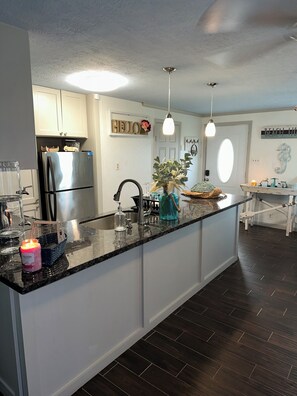 Enjoy cooking in this well-lit kitchen with a sleek island and sink.