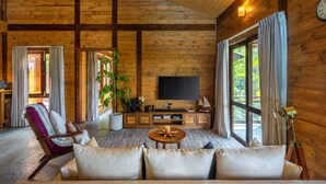 A cozy cabin interior with a wooden interior, a large TV, and a comfortable seating area.