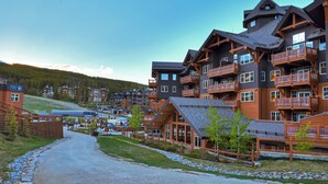 A lodge with multiple balconies and a ski slope in the background.
