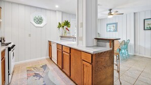 Een moderne keuken met houten kastjes, een ingebouwde vaatwasser en een groot raam.