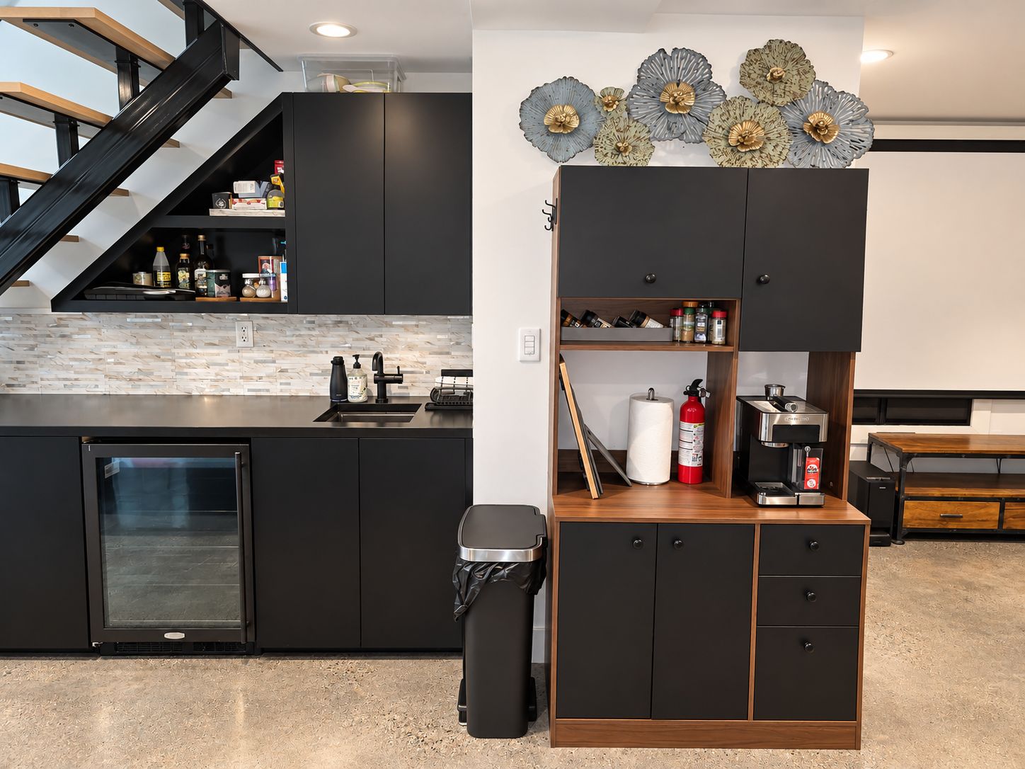 A modern kitchen with a built-in dishwasher, a coffee machine, and a trash can.