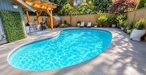 A swimming pool with a wooden deck and lounge chairs. - 2 bedroom Guest Suite with Pool & Sauna access (West Vancouver)