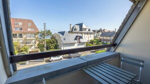 A balcony with a view of residential buildings and parked cars. - Duplex Les Mouettes - Welkeys (Cabourg)