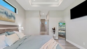 Un dormitorio moderno con una cama grande, un televisor de pantalla plana y un tragaluz.
