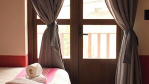 A room with a bed, a window with curtains, and a tiled floor. - Lidia Anturios Suites (Oaxaca)