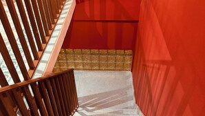 A staircase with wooden railings and a red wall. - Lidia Anturios Suites (Oaxaca)