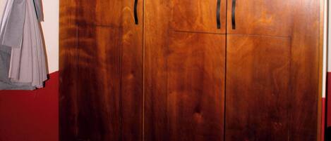 A large wooden wardrobe with two doors and a handle on each door.