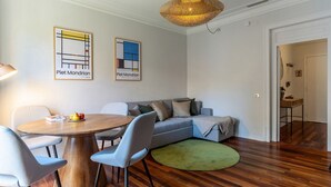 A modern living room with a round wooden table, grey sofa, and a green rug. - Beautiful apartment near Plaza Catalunya (Barcelona)