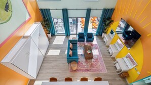 A modern interior with a sofa set, a dining table, and a kitchen area. - Tequila Sunrise Downtown Condo, Walk to Broadway! (Nashville)