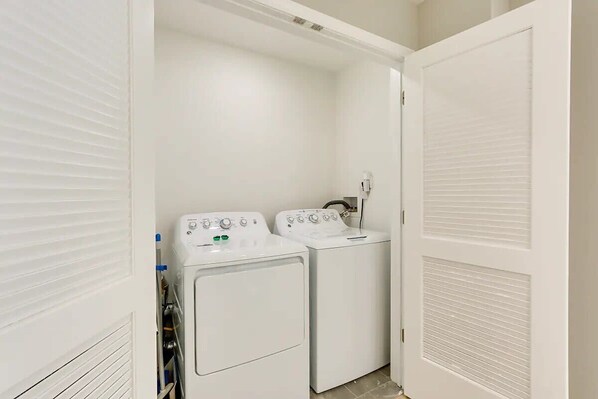A laundry room with two white front-loading washing machines and a dryer. - Modern City Getaway Near Downtown Newark & NYC (Newark)