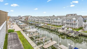 A marina with boats docked, a waterway, and row houses with balconies.