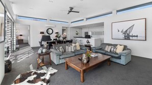 A spacious living room with a grey sofa set, a wooden coffee table, and a cowhide rug. - Lake & Mountain views, close to ski fields. Executive living - 3 bed/3 bath, spa (Wānaka)