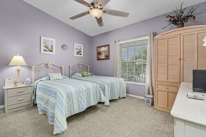 A bedroom with two beds, a ceiling fan, a desk, and a window with blinds. - Condo in Naples Walk! 2 Miles to the Beach! (Naples)