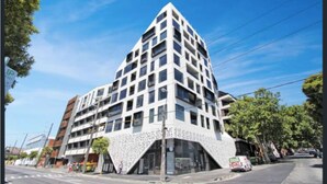 A modern multi-story building with a unique architectural design, featuring a prominent triangular section at the base.