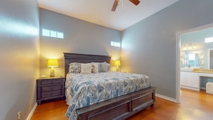 A bedroom with a bed, nightstands, and a ceiling fan. - PB205 Shared Pool. Pet Friendly, Parking for 2 Vehicles (Port Aransas)