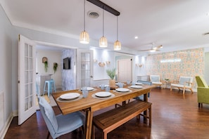 Enjoy meals in this dining area with a long table for four, a large mirror, and a mounted TV.