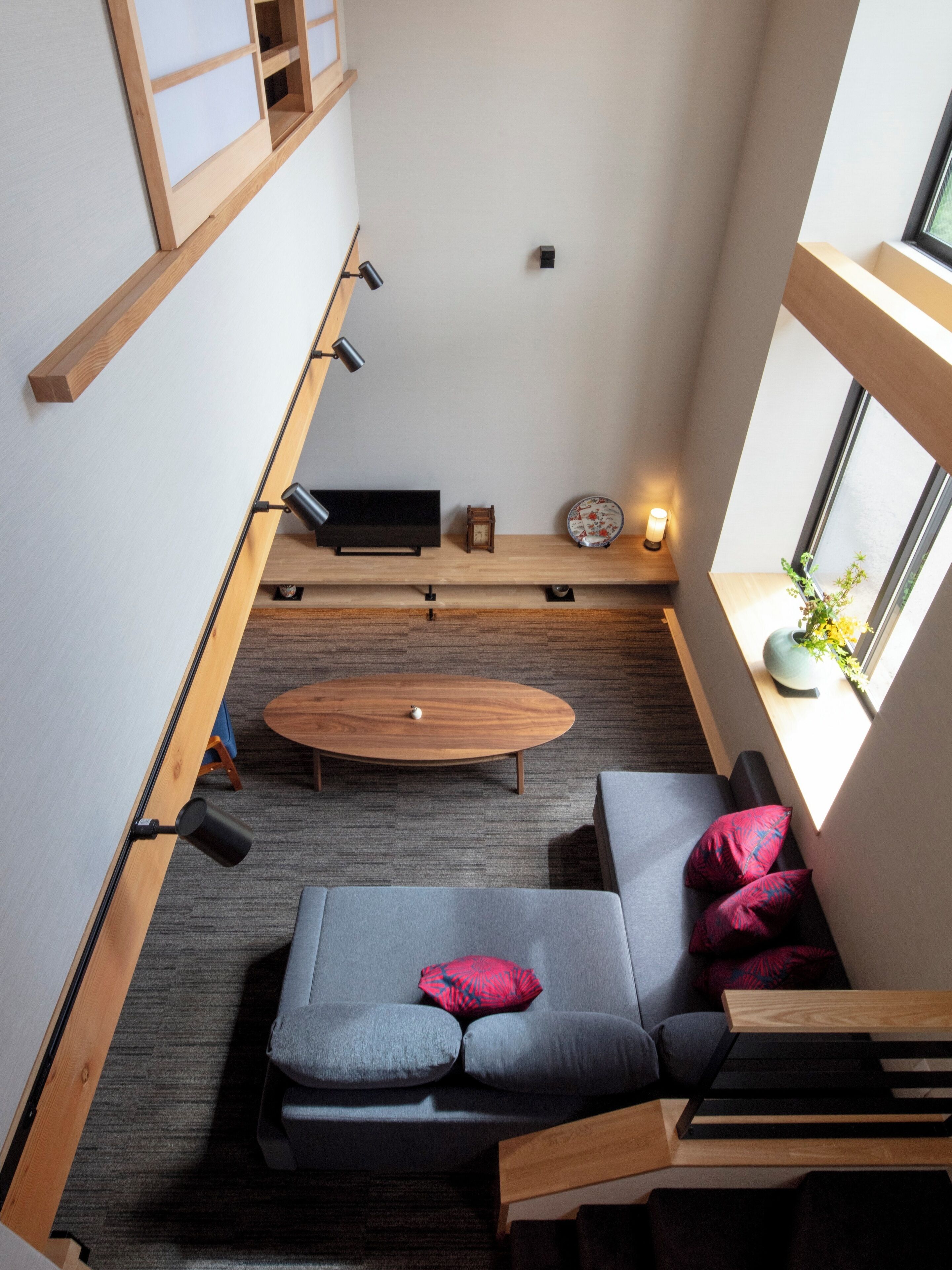 Un espacio habitable compacto con un sofá, una mesita y una ventana con una planta.