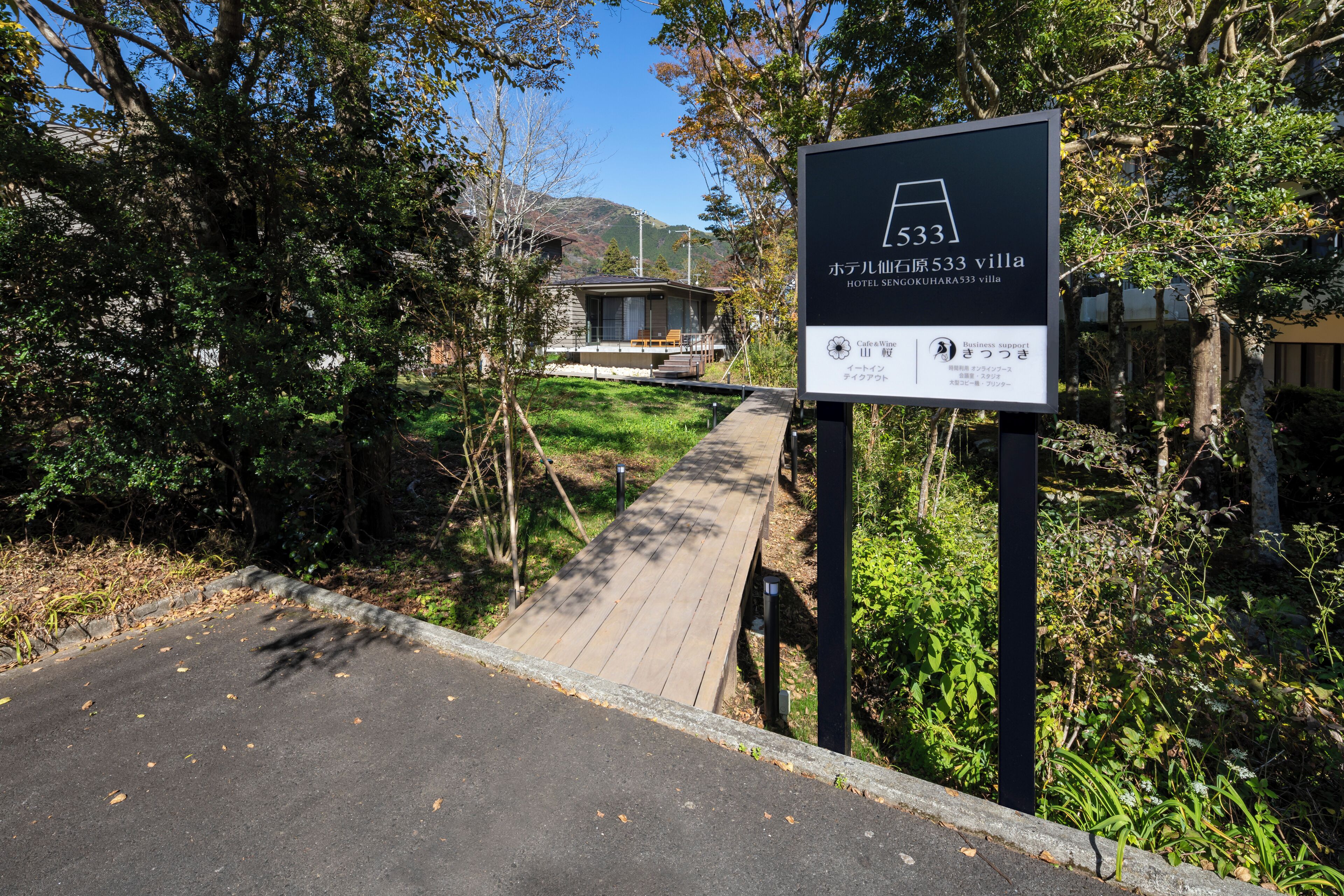 Schild für Villa Hotel Sengoku Hara 533 mit einer Holzterrasse, die zum Eingang führt.