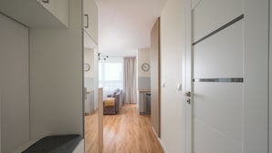 Een moderne hotelkamer met een houten vloer, een bank, een bureau en uitzicht op zee.