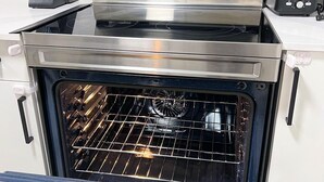 A stainless steel oven with a digital display, a built-in range hood, and a pizza stone. - Guest Suite in SouthWest Edmonton (Edmonton)