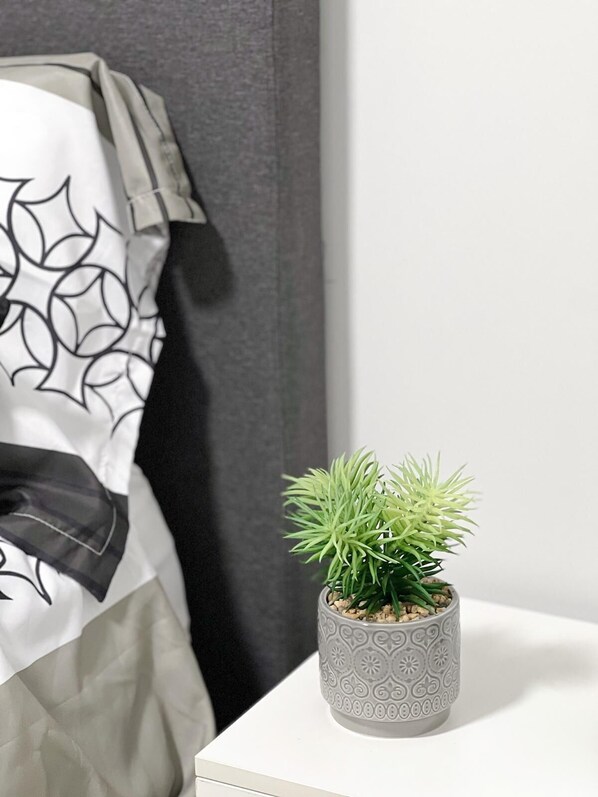 A potted plant on a white surface next to a gray wall. - Guest Suite in SouthWest Edmonton (Edmonton)