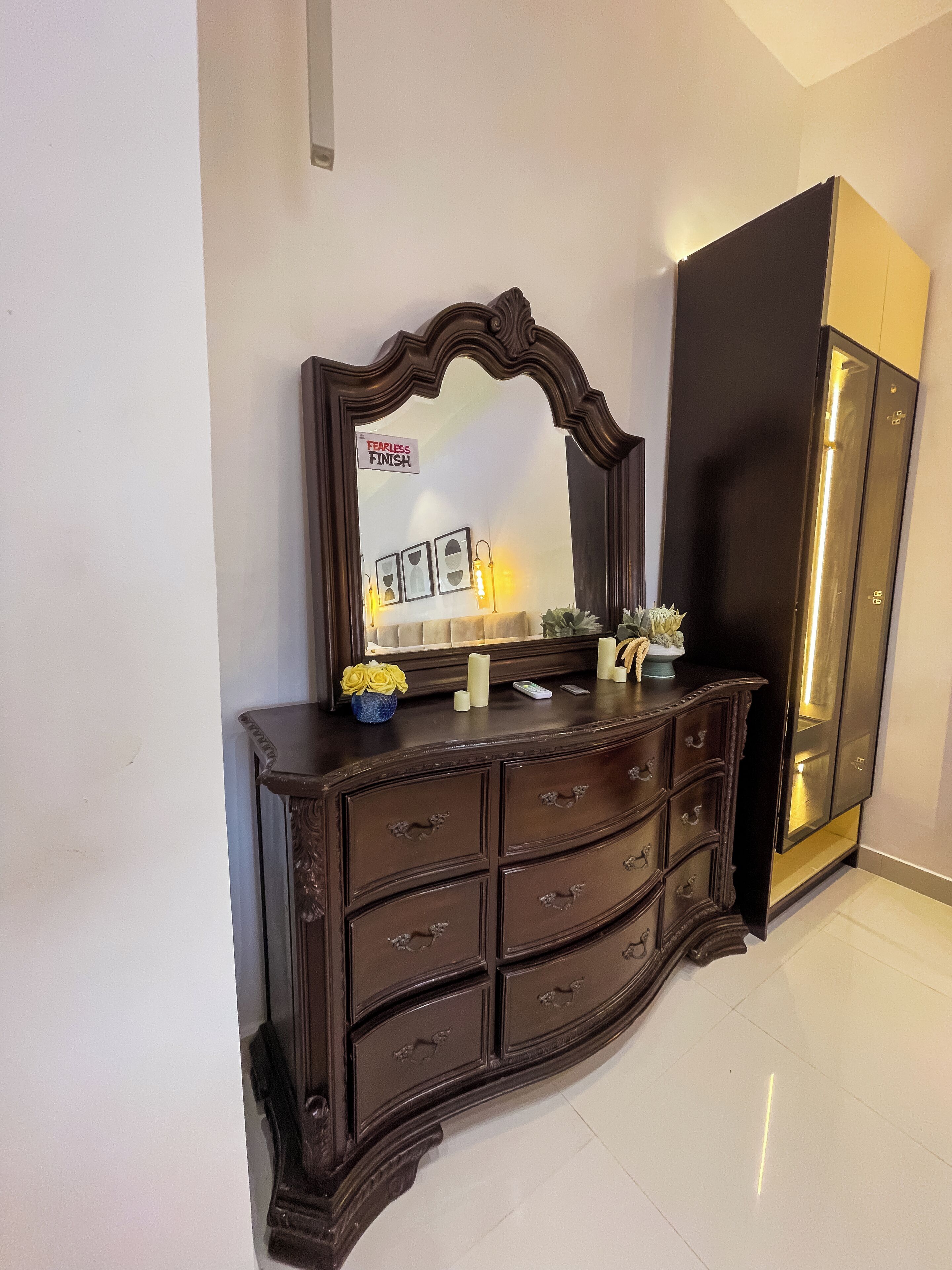 A dark wooden dresser with multiple drawers and a mirror above it.