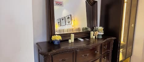 A dark wooden dresser with multiple drawers and a mirror above it.