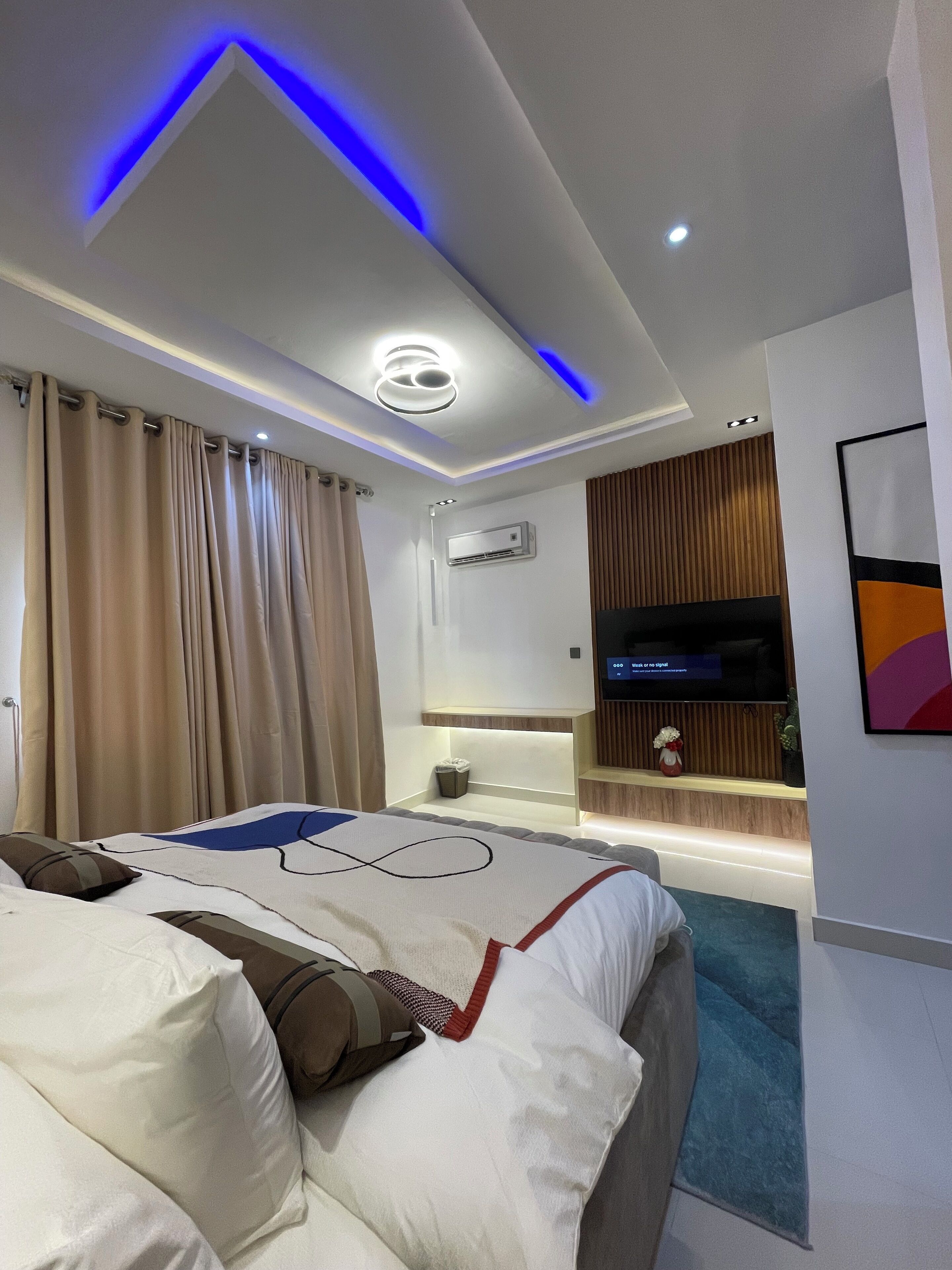 Een moderne hotelkamer met een groot bed, een flatscreen televisie en een ingebouwde airconditioning.