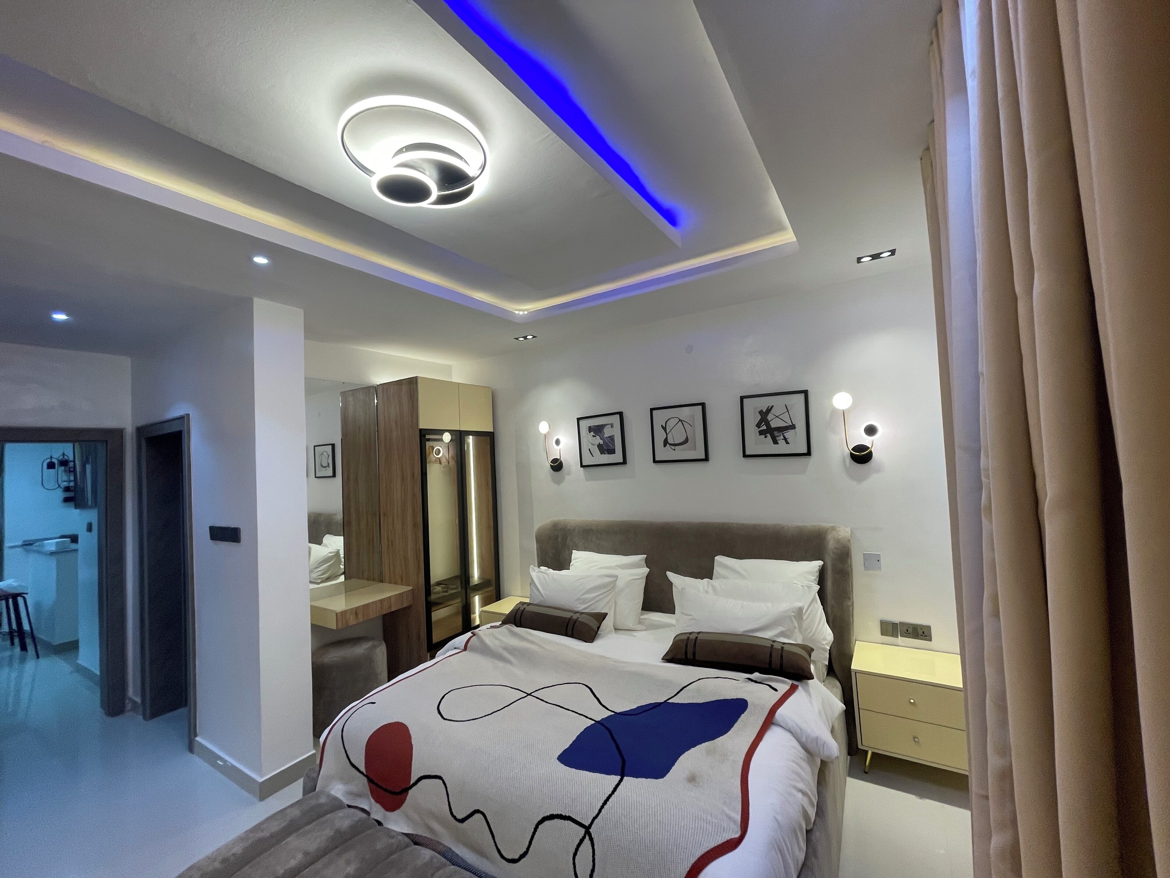 A modern bedroom with a bed, bedside tables, and a wardrobe.