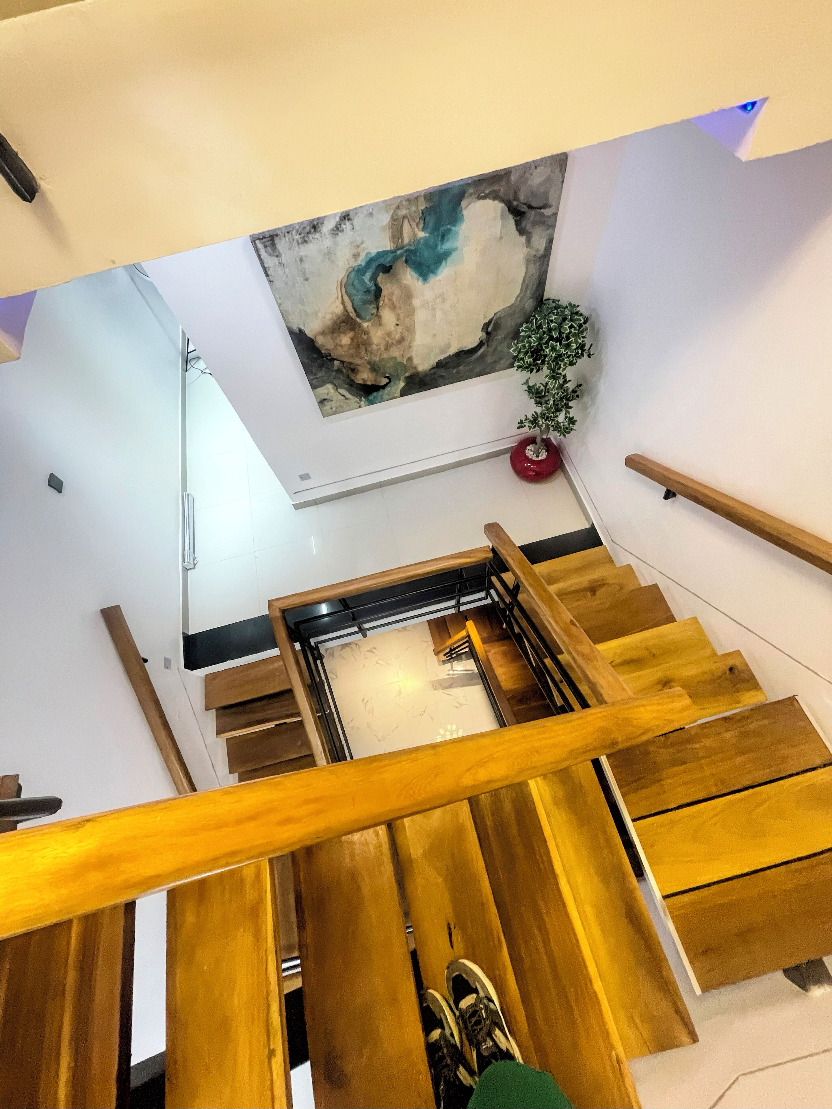 A wooden staircase with a view of a room below.