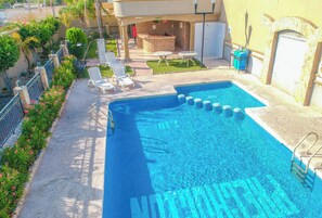 A swimming pool with lounge chairs and a bar area. - Hotel San Martin (Hermosillo)