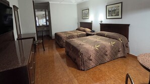 A hotel room with two beds, a ceiling fan, a TV, and a dining area. - Hotel San Martin (Hermosillo)