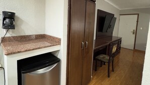 A compact kitchen with a built-in dishwasher, a wooden cabinet, and a countertop. - Hotel San Martin (Hermosillo)