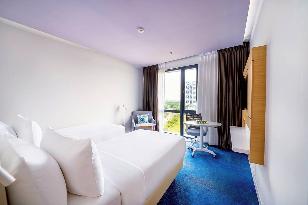 Une chambre d’hôtel avec un grand lit, un bureau et une chaise.