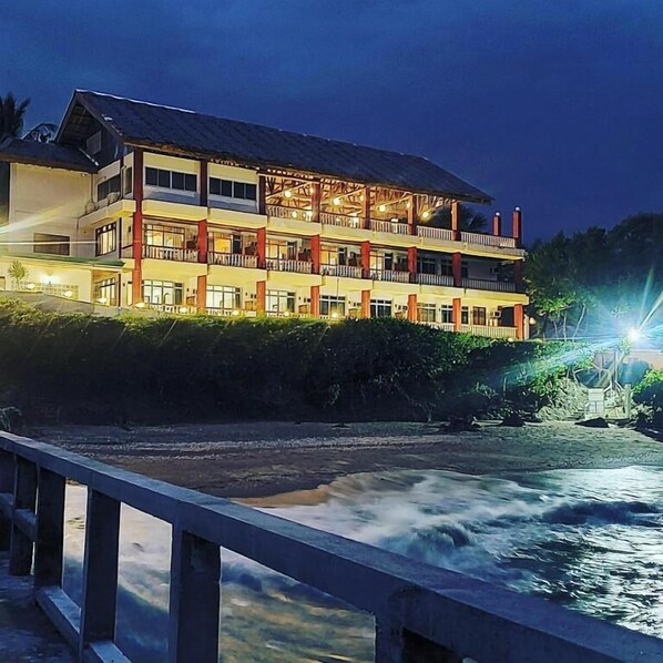 A multi-story hotel with balconies, located near a body of water. - Wuthering Heights Bed and Breakfast (San Jose)