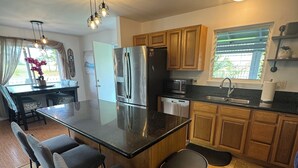 Una cocina moderna con una isla central, electrodomésticos de acero inoxidable y armarios de madera.